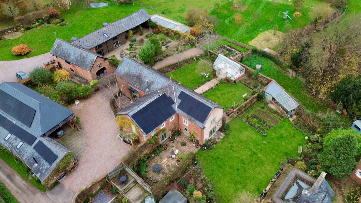 An aerial photo of solar panels on a house and barn