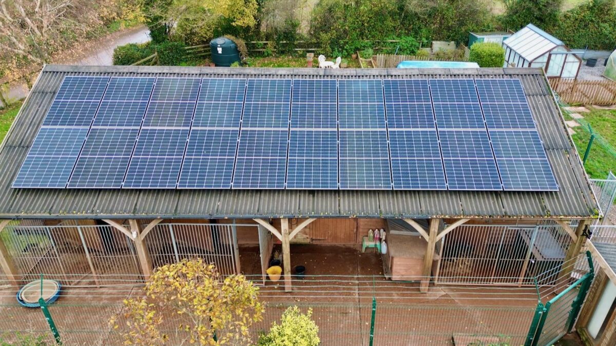 An aerial photo of solar panels on a barn roof