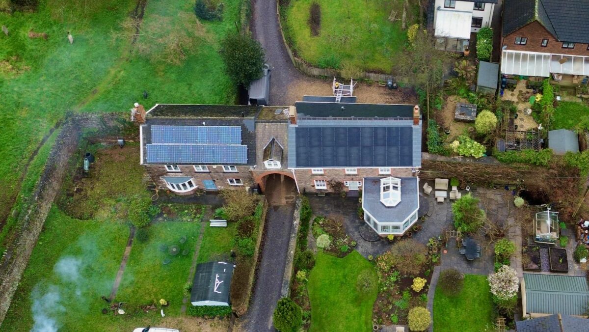 An aerial photo of solar panels on a large house